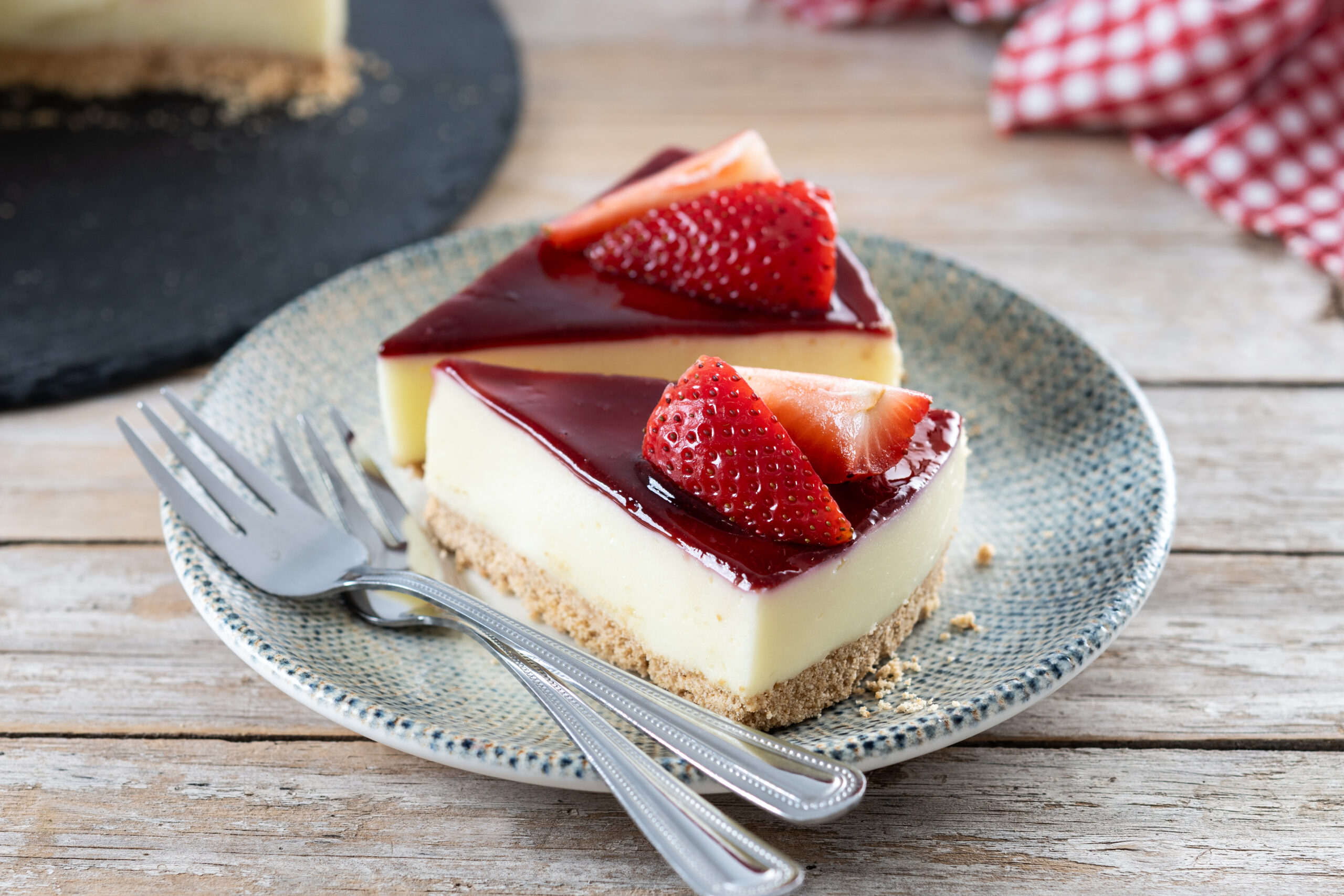 slice of cheesecake with strawberries on wooden table